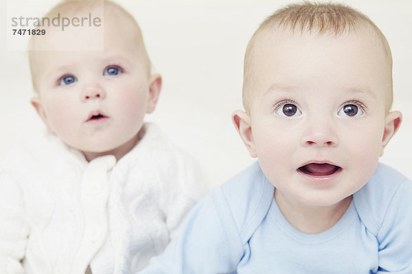 Babys sitzen zusammen auf dem Sofa