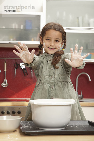 Mädchen mit klebrigen Händen in der Küche
