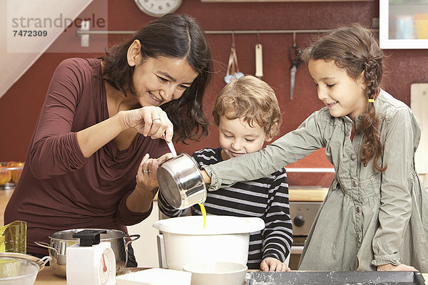 Mutter und Kinder kochen in der Küche