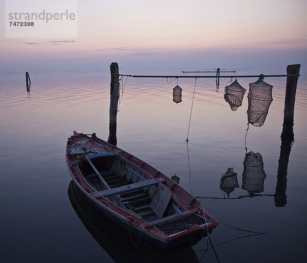 Fischerboot mit Netzen im stillen Wasser