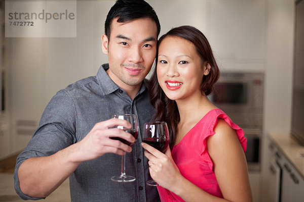 Paare toasten sich mit Wein.