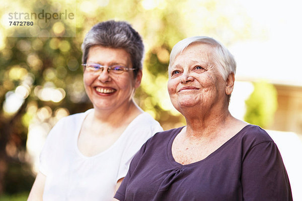 Ältere Frauen lächeln gemeinsam im Freien