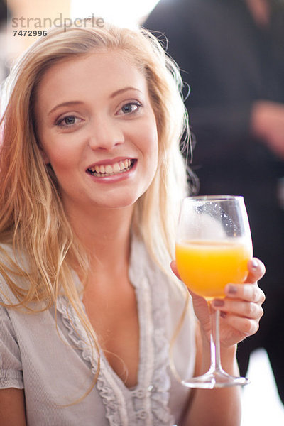 Frau mit Orangensaft im Café