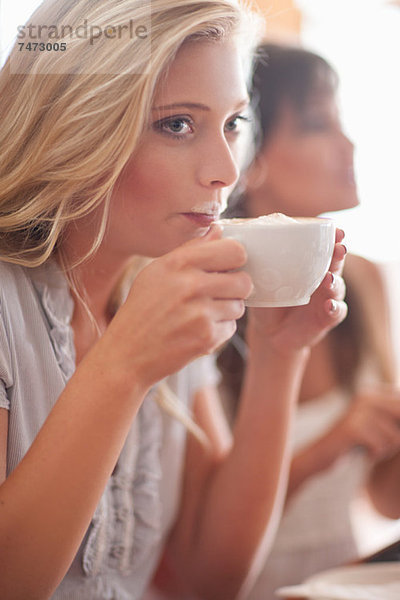Frau mit Milchschnurrbart im Café