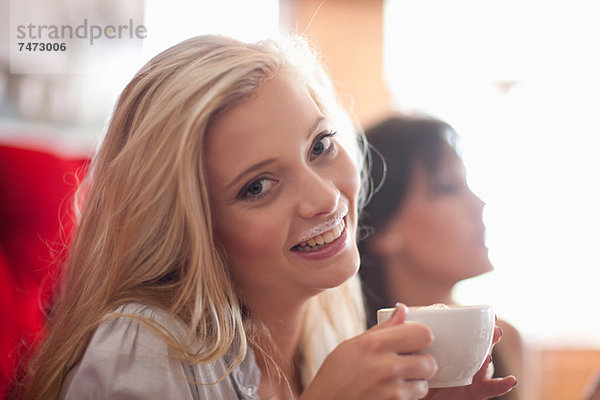 Frau mit Milchschnurrbart im Café