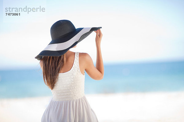 Frau mit Schlapphut am Strand