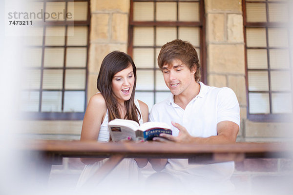 Paare lesen Reisebuch zusammen