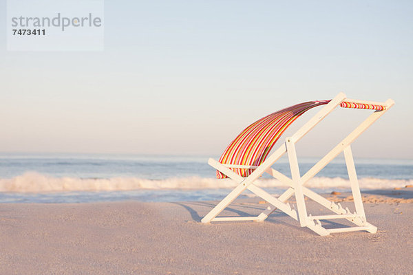 Liegestuhl am leeren Strand