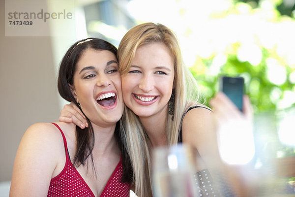 Lächelnde Frauen beim gemeinsamen Fotografieren