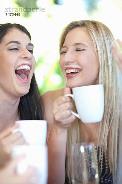 Frauen  die lachen und Kaffee trinken