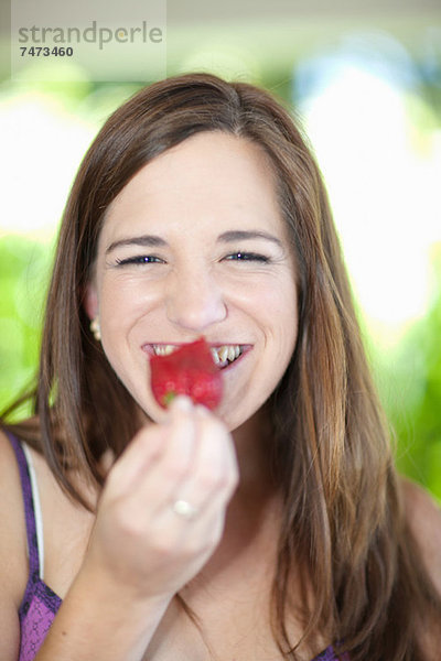 Frau isst Obst im Freien