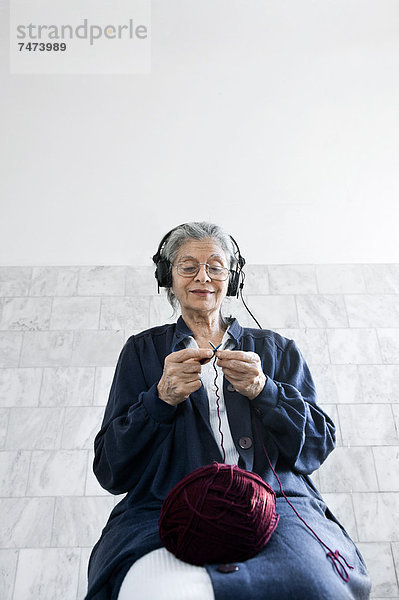 Frau  zuhören  Kopfhörer  stricken