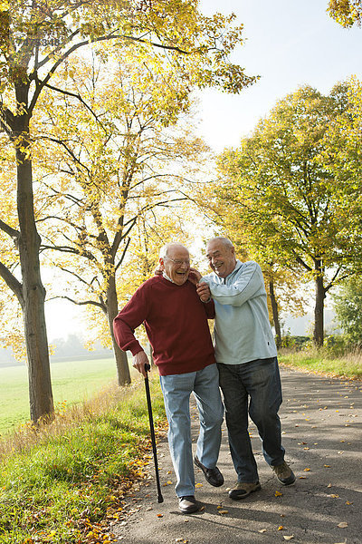 Senior Senioren Mann gehen Baum Weg Herbst Menschenreihe