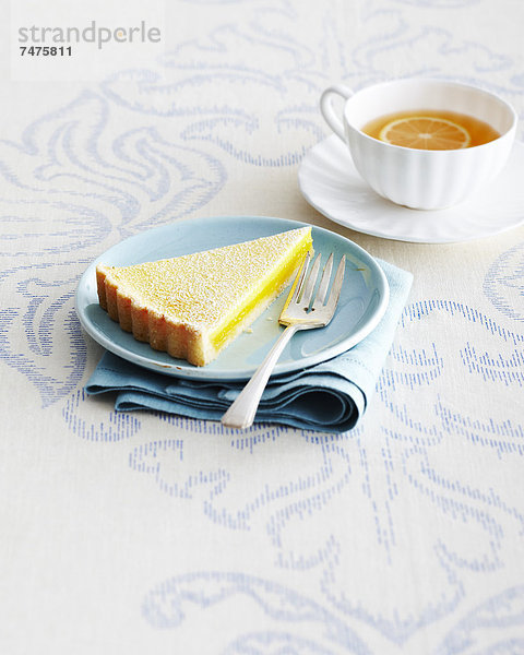 Torte  Tasse  Scheibe  Teller  blau  Zitrusfrucht  Zitrone  Untertasse  Studioaufnahme  Gabel  Gewürz  Tischdecke  Tee