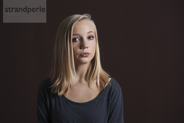 Portrait of Blond  Teenage Girl Looking at Camera  Studio Shot on Black Background