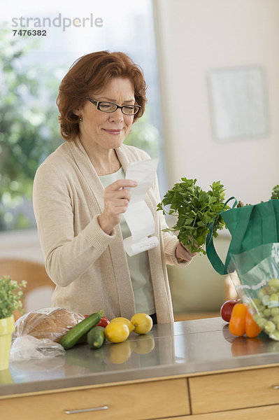 Senior Senioren Frau Küche kaufen Liste vorlesen