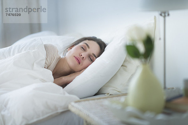 Frau schläft im Bett