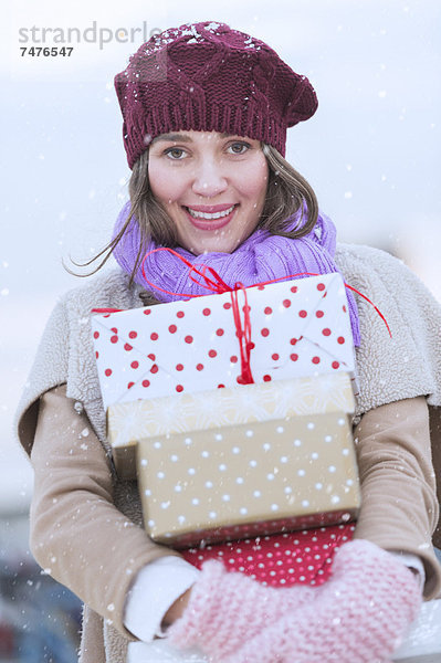 Geburtstagsgeschenk  Stapel  Portrait  Frau  tragen  Weihnachten  jung  Felssäule