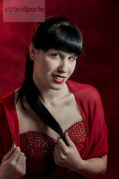 Junge Frau mit langen schwarzen Haaren in rotem Kleid  Portrait