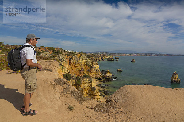 56-jähriger Tourist genießt die Aussicht  Praia do Camilo  hinten Praia Dona Ana  Lagos  Algarve  Portugal  Europa
