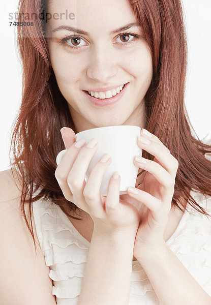 Junge Frau mit einer weißen Tasse in den Händen