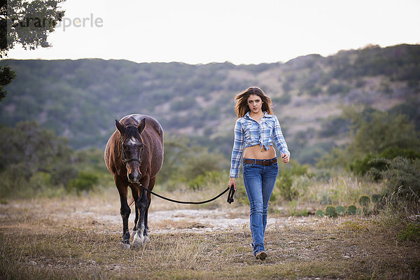USA  Texas  Cowgirl beim Wandern mit Pferd