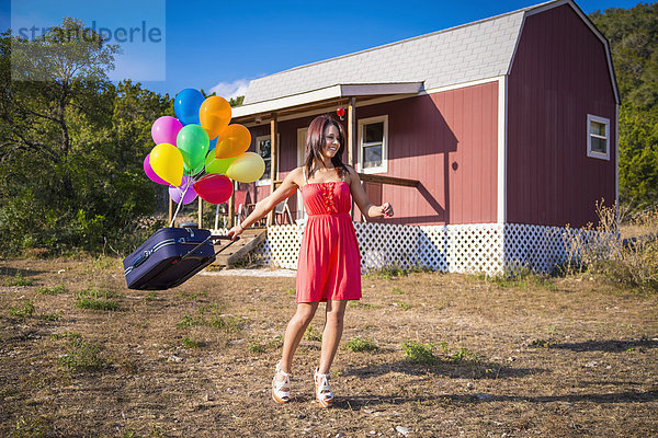 USA  Texas  Junge Frau mit Koffer und Ballon