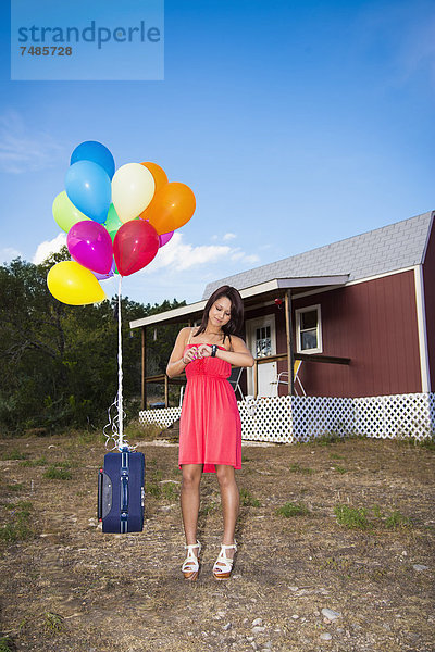 USA  Texas  Junge Frau mit Koffer und Ballons