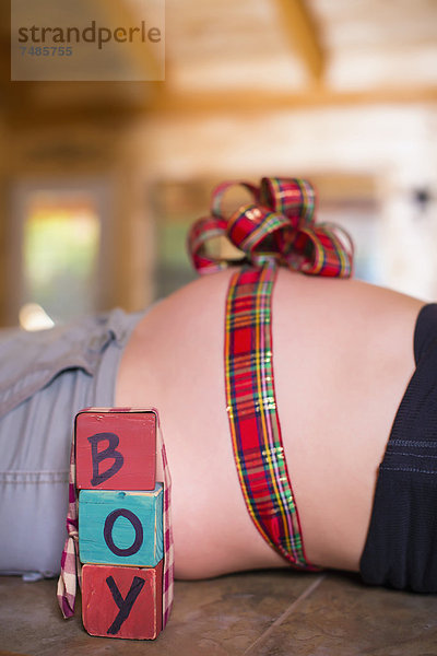 USA  Texas  Schleife in einer Schleife um den schwangeren Bauch gebunden mit Buchstabenblöcken