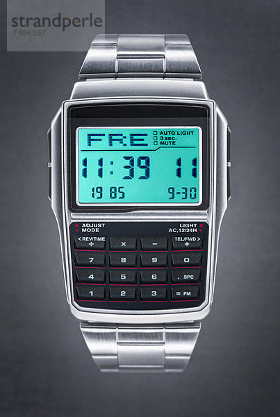 Digitaluhr mit Taschenrechner vor schwarzem Hintergrund  Nahaufnahme