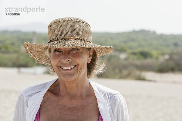 Spanien  Seniorin am Strand  lächelnd
