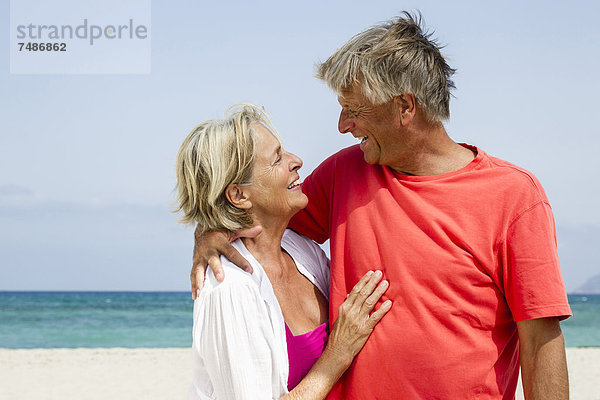 Spanien  Senior Paar Romantik am Strand  lächelnd