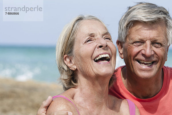 Spanien  Seniorenpaar am Strand  lächelnd