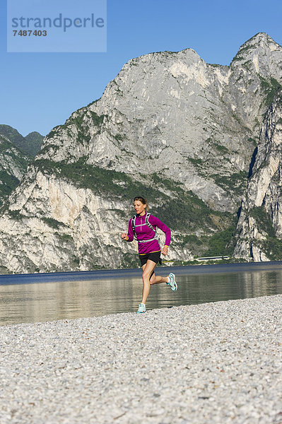 Italien  Mid adult woman jogging am Gardasee