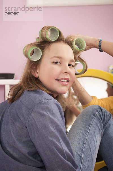 Mädchen mit Haarroller beim Schminken