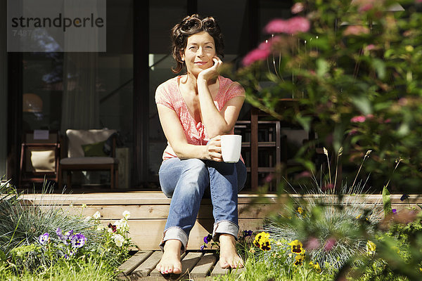Reife Frau entspannt auf der Terrasse  lächelnd  Portrait