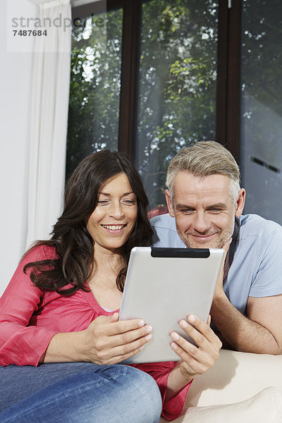 Deutschland  Berlin  Ehepaar mit digitalem Tablett  lächelnd
