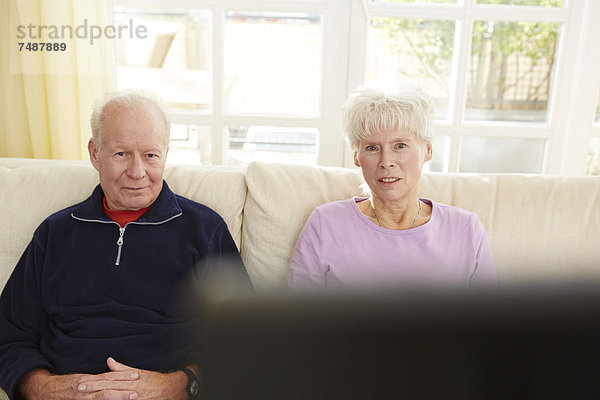 Deutschland  Düsseldorf  Seniorenpaar beim Fernsehen und Entspannen zu Hause