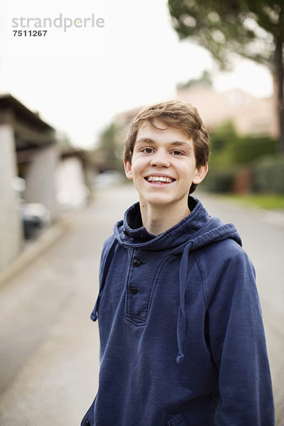 Portrait eines glücklichen Jungen  der auf der Straße steht