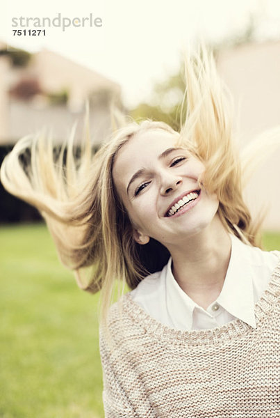 Porträt eines fröhlichen jungen Mädchens  das Haare wirft.