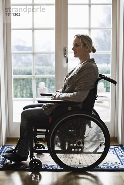 Seitenansicht der behinderten Frau im Rollstuhl zu Hause