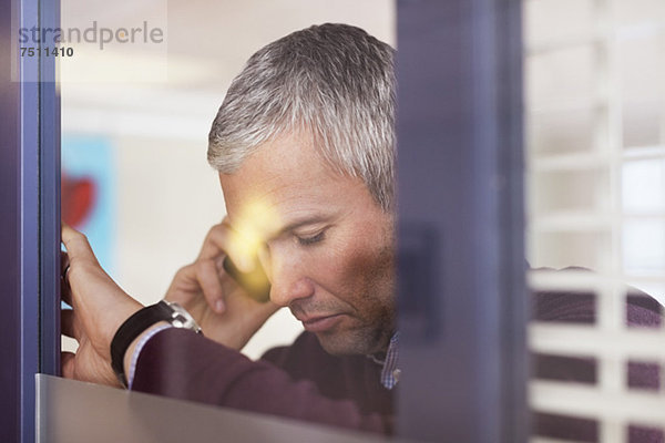 Reife Geschäftsleute mit Handy im Büro