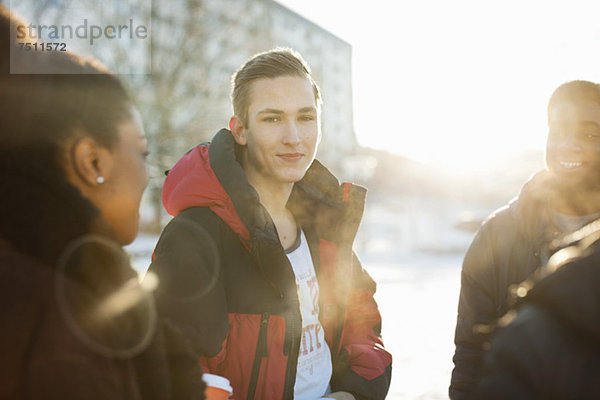 Porträt eines jungen Mannes mit Freunden im Winter