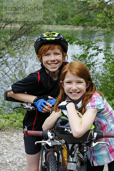 Zwei Kinder  Junge und Mädchen  beim Radfahren  Mountainbiken  mit Fahrrädern und Helmen
