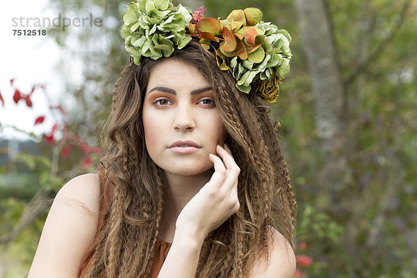 Junge Frau mit Blumenkranz im Haar  draußen  Portrait