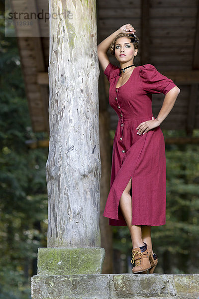 Holzpfosten Pfosten Pfahl junge Frau junge Frauen Hütte Pose Wald Kleidung Dirndl Kleid