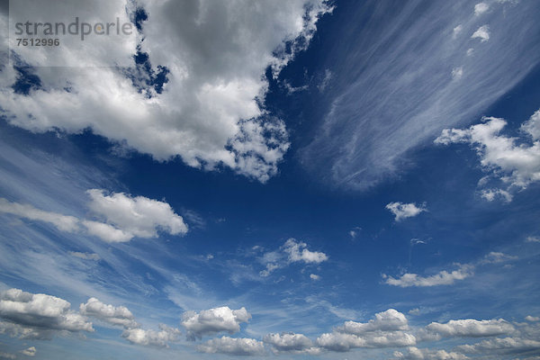 Cumuluswolken und Schleierwolken am blauen Himmel