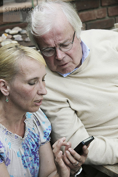 Junge Frau erklärt Senior Smartphone
