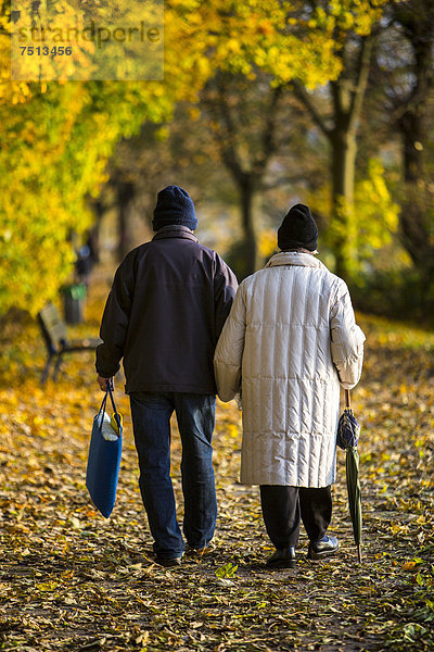 Senioren  Rentner  Paar bei einem Herbstspaziergang  Händchen haltend