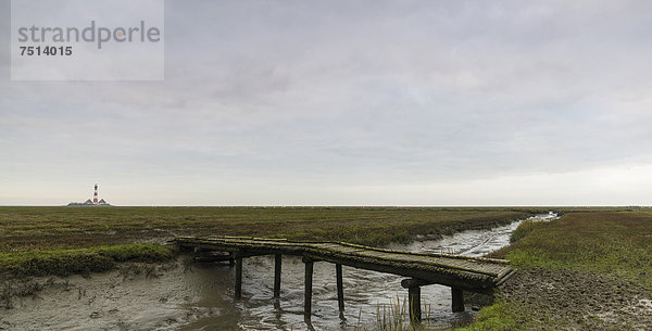 Warft  Holzsteg  Westerheversand  hinten der Leuchtturm  Halbinsel Eiderstedt  Kreis Nordfriesland  Schleswig-Holstein  Deutschland  Europa